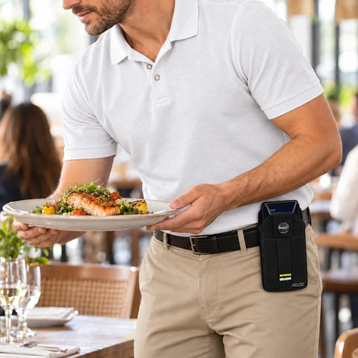 Restaurant server carrying a plated meal while wearing an Agoz Dejavoo QD3 mPOS holster on his waist belt, demonstrating hands-free device storage during table service.