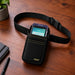 GoDaddy Smart Terminal Flex in an Agoz waist belt holster displayed on a wooden tabletop.