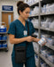 Nurse in teal scrubs wearing a Rhino tablet case in a hospital supply room.