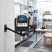 SATO mobile printer secured in an AgozTech adjustable swing arm mount with metal holder near a warehouse conveyor station.