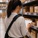 Worker wearing an AgozTech shoulder sling holster while checking inventory on warehouse shelving.