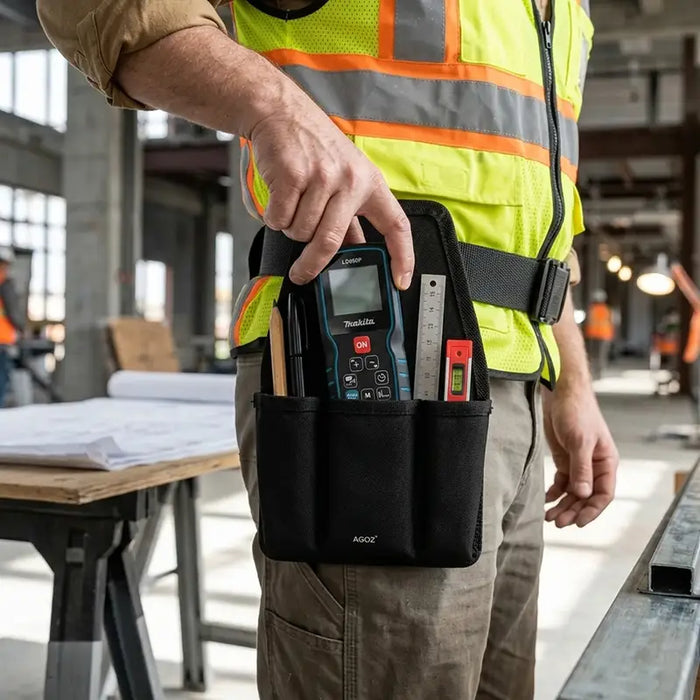 Close-up of construction worker retrieving a Makita laser distance measure from an Agoz utility tool pouch attached to his waist belt.