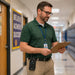 School staff member wearing AgozTech Icom Radio Holster on waist belt while checking clipboard in hallway