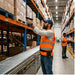 Warehouse worker scanning high-shelf inventory with a handheld barcode scanner while wearing an AgozTech belt holster for scanner carry.