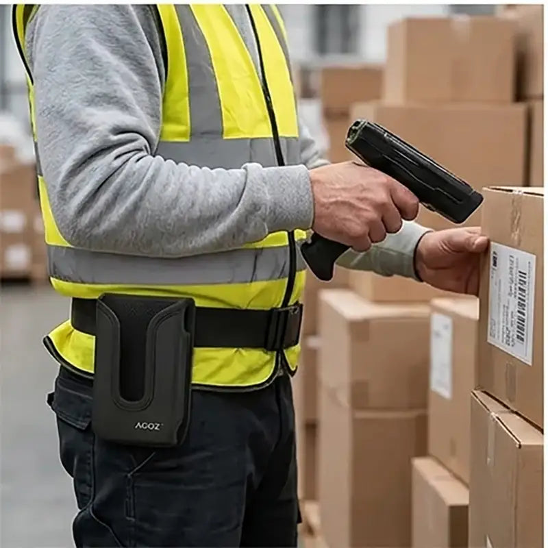 Warehouse worker scanning carton labels with a Panasonic Toughbook trigger scanner while wearing an Agoz belt holster.