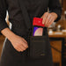 Restaurant server wearing an AgozTech crossbody sling pouch holding an iMin Handheld POS terminal.